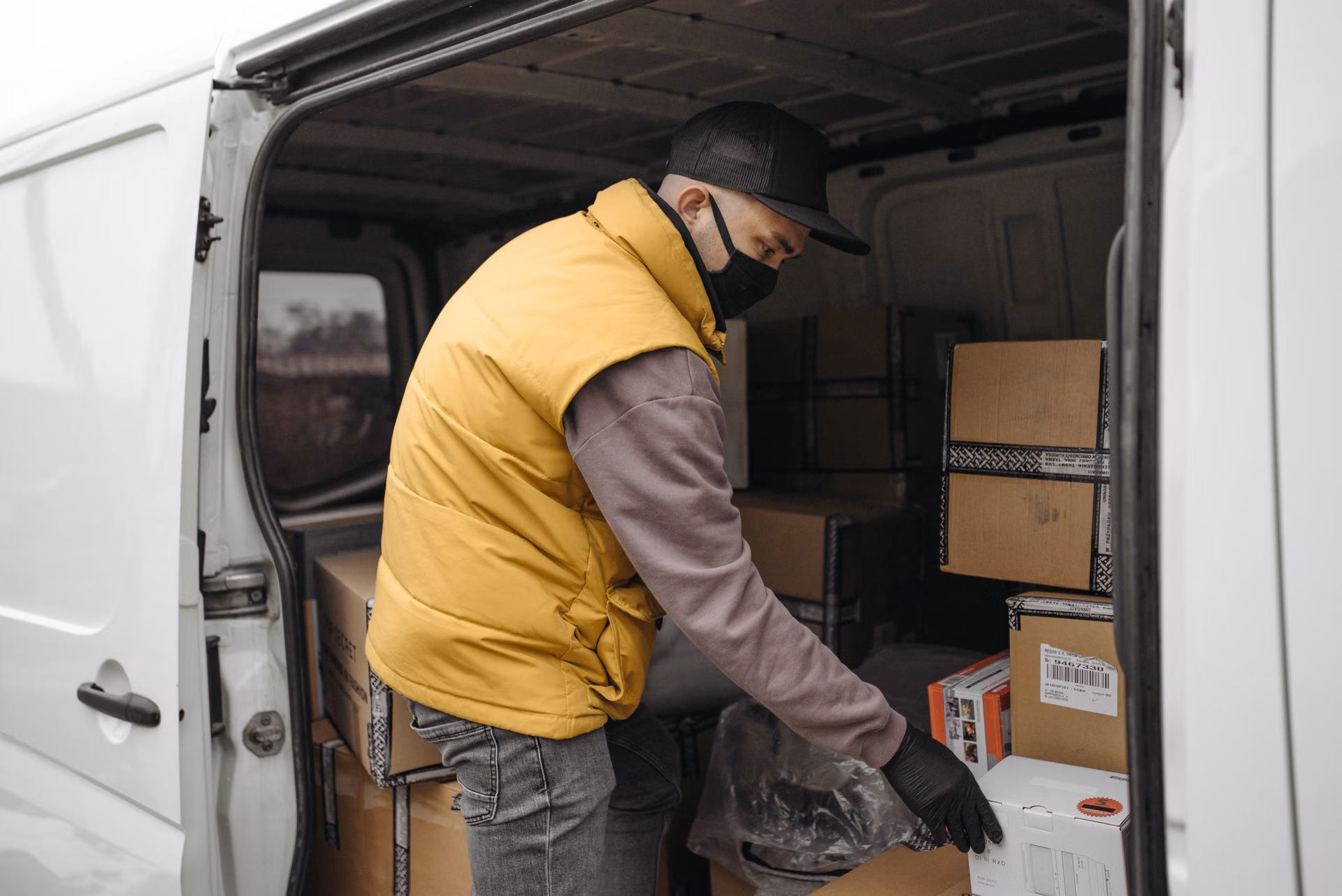 Crew member loading bags and boxes into a cargo van