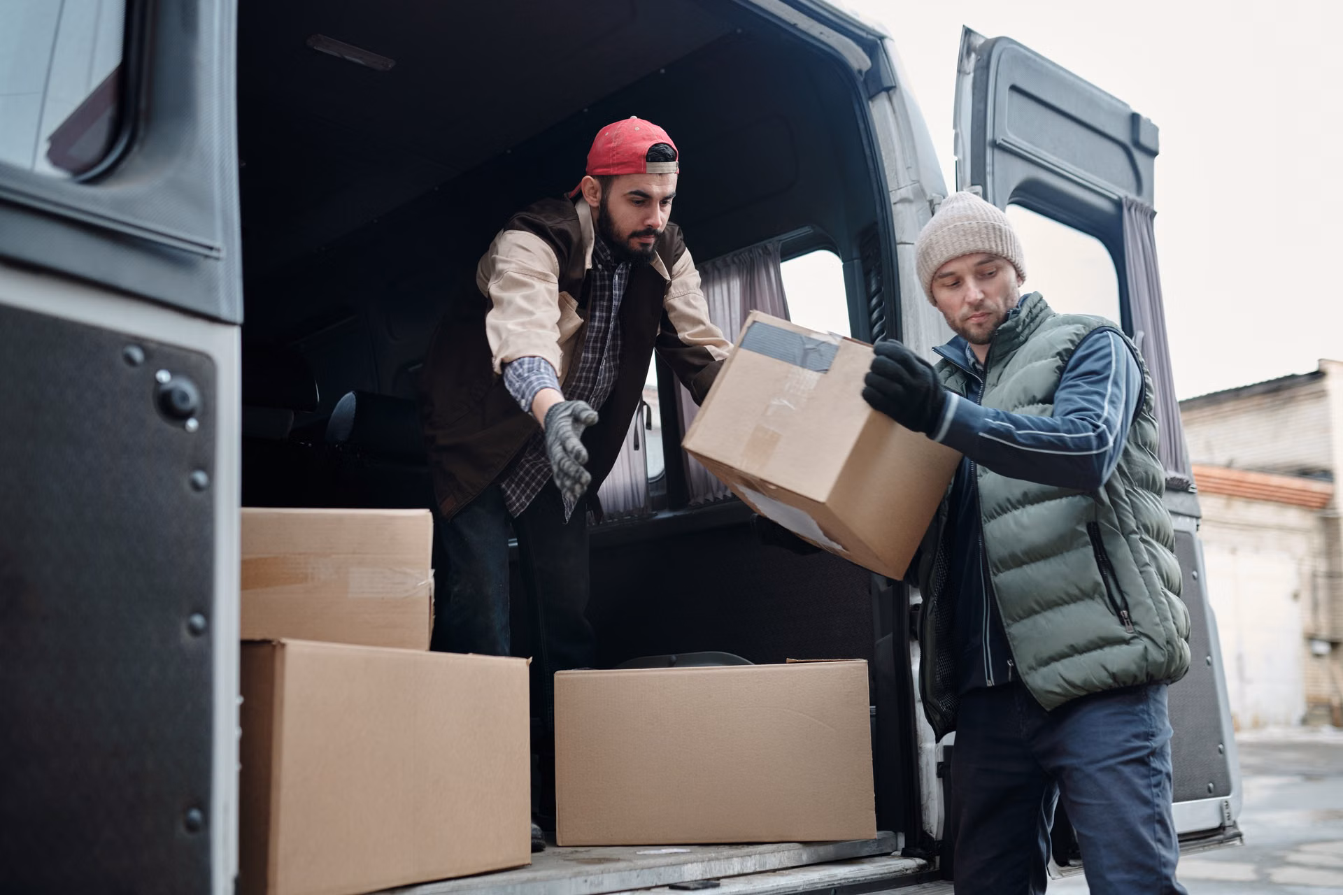 Crew member handing a box down from a loaded van