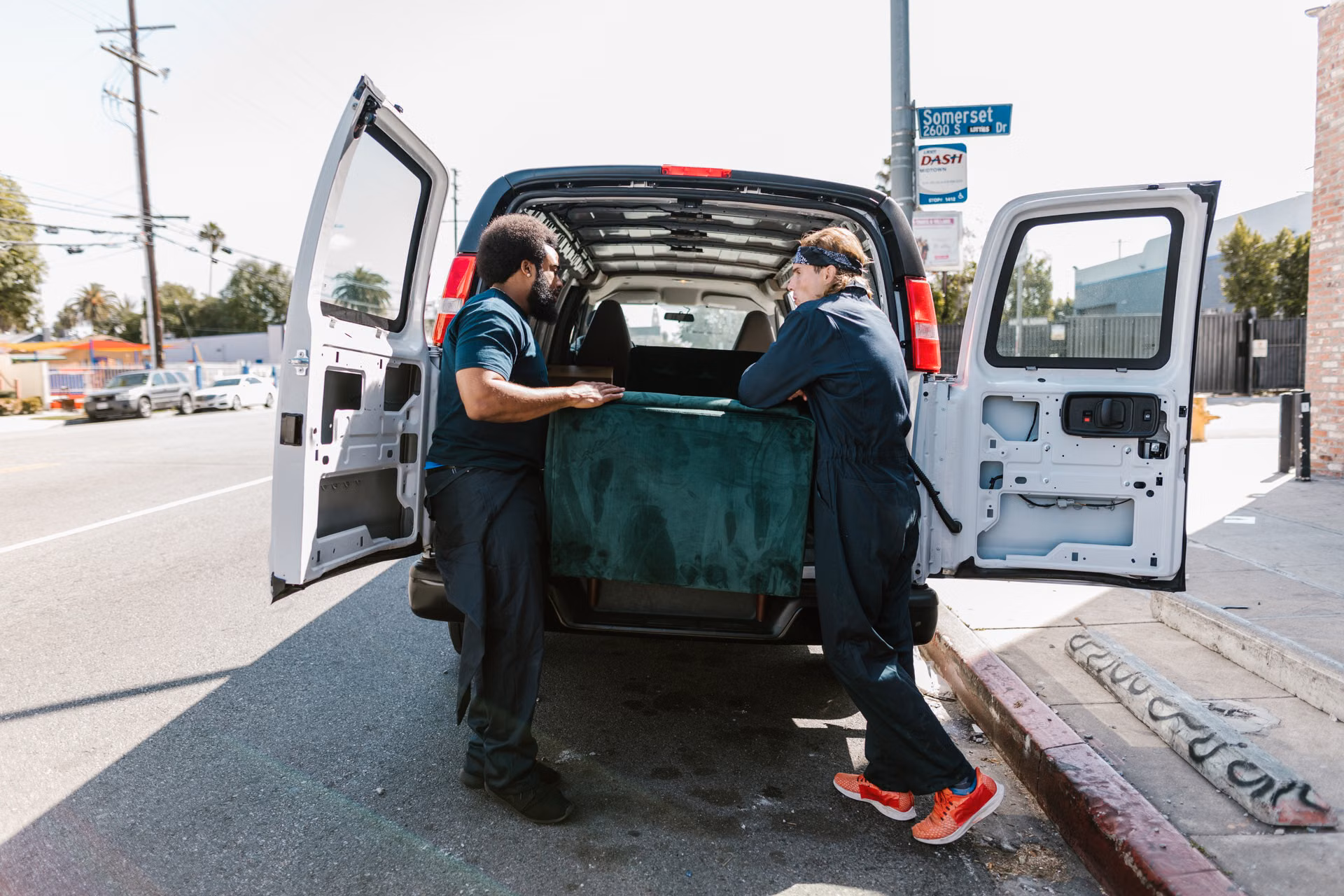 Crew loading a couch into the back of a van